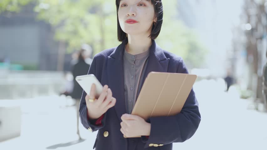 Young businesswoman walking on street corner