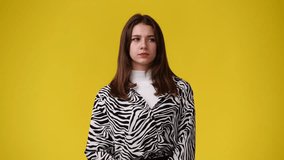 4k slow motion video of a girl thinking about something over yellow background.