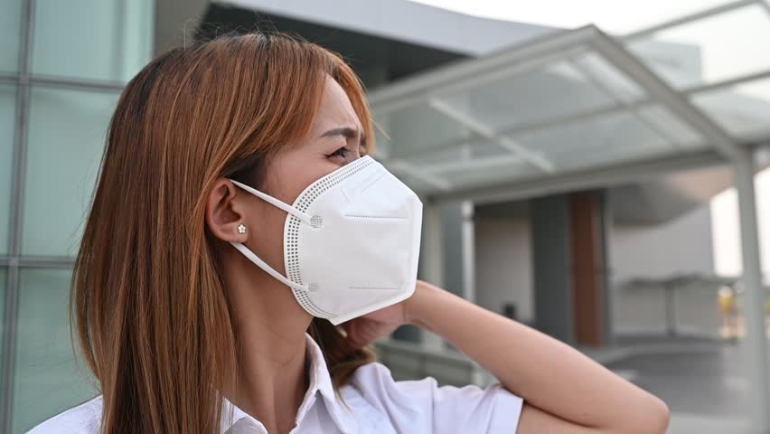 Asian woman wear N95 mask for protect dust pm 2.5,ecology concept. Allergy, headache. air danger in city. | Shutterstock HD Video #1102048317