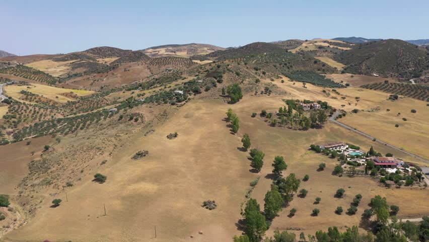 Countryside of Spain. Hills with agriculture. Olive tree farms. 
Fields of threshed wheat.  Beautiful landscape in South of Spain, Andalucía province. Drone descending