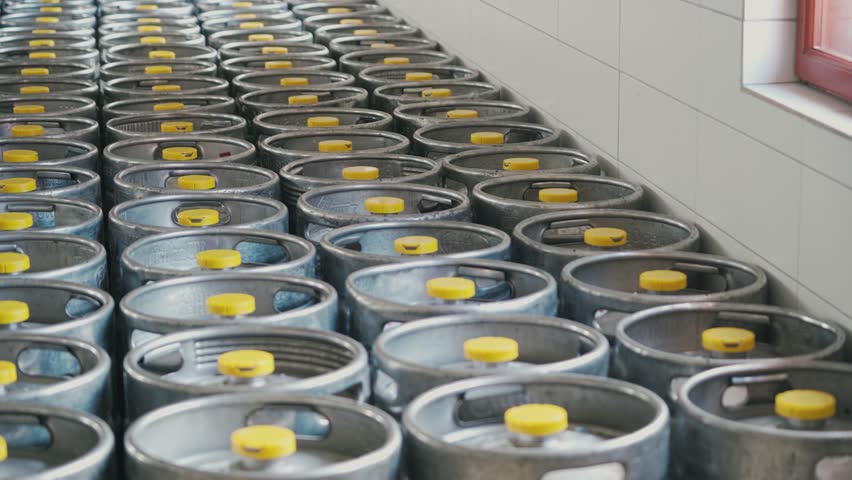 Stainless steel beer keg barrels where the finished beer is stored for sale at the brewery.