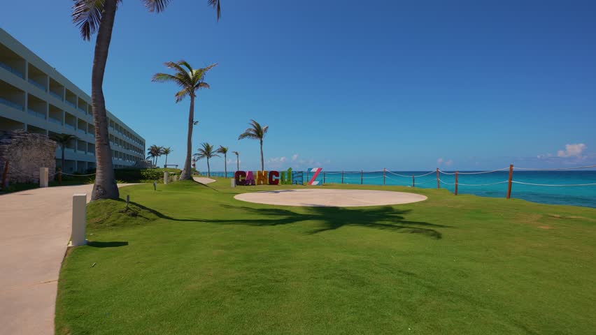 Cancun, inscription in front of the shores of the Caribbean Sea in the  hotel zone Cancun. Huge letters of the city name. Mexico. Punta Cancun lighthouse on a background.