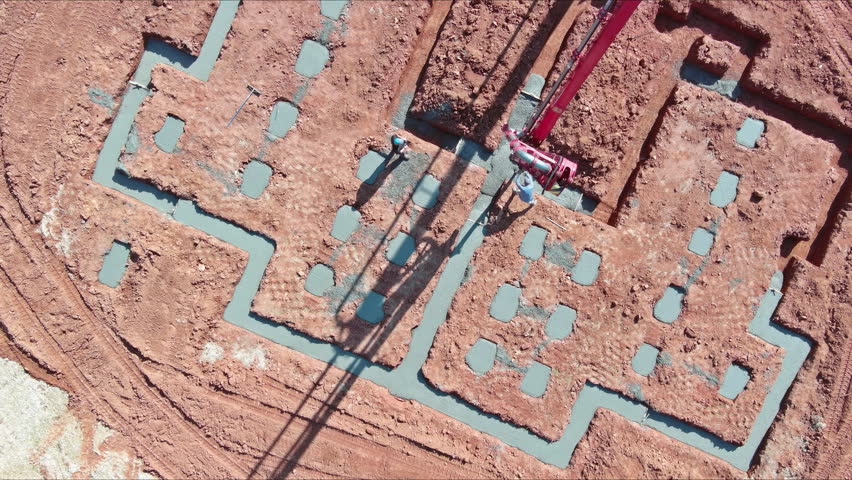 An automatic pump is used to direct cement concrete in construction process of house using concrete strip foundations.