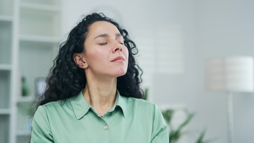 Calm employee worker practices yoga at workplace in the office Happy woman freelancer employee meditating relaxes in the office Serene carefree female sitting at a computer desk rest and ralax indoor