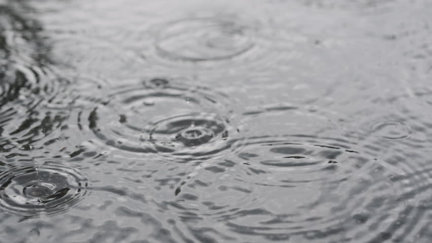 Slow motion closeup of summer heavy rain drops falling into puddles on asphalt Royalty-Free Stock Footage #1102063087