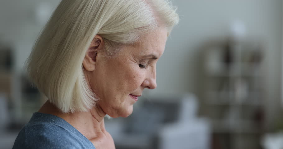 Close up side profile face view mature woman raise head open her eyes smile looks straight, enjoy, welcomes new day, feel happy, enjoy carefree untroubled retired life pose indoor. Eyesight and vision Royalty-Free Stock Footage #1102066415