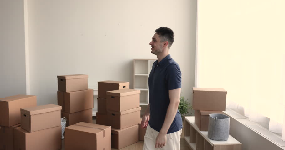 Happy loving husband spinning wife congratulate her with relocation, enjoy moment of move day to their new, first house purchase, boxes with stuff nearby. Bank loan, affordable home for young family Royalty-Free Stock Footage #1102066431