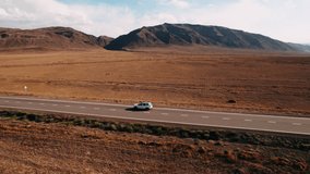 Off road 4x4 car driving along road path near arid desert mountains, Aerial shot. People traveling, road trip through beautiful desert scenery in sunny summer. Kazakhstan Highway road trip adventure - Powered by Shutterstock - Get 15% off with code: PIKWIZARD15