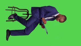 Vertical video: Side view of african american man thinking about business notes on papers, brainstorming new ideas on clipboard files. Young business person sitting on chair in studio, feeling