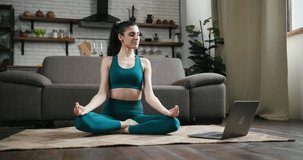 Transgender woman teaches followers to meditate right at online course. Hispanic trans communicates with students through video-call on laptop