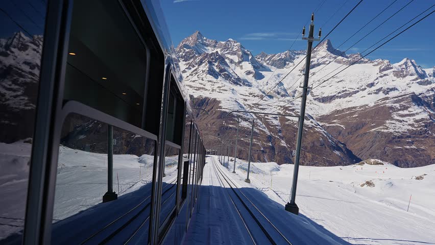 Riding the iconic cogwheel Gornergrat railway in Zermatt ski resort in the Swiss Alps in Valais, Riding a train in Switzerland on a sunny winter day