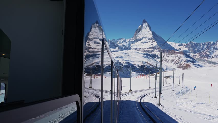 Riding the iconic cogwheel Gornergrat railway in Zermatt ski resort in the Swiss Alps in Valais, Riding a train in Switzerland on a sunny winter day