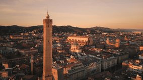 aerial shot drone of bologna city historic center at sunrise,flying over view asinelli tower,san petronio basilica and town hall in the background
