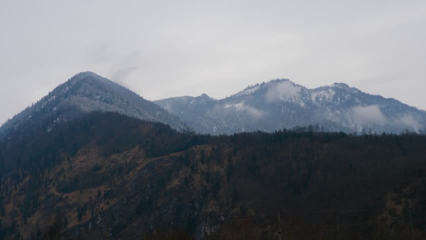Ebensee, Austria. Mountaintop the austrian alps on a moody, cloudy day. Clouds covering the snowy, frozen forrests. 