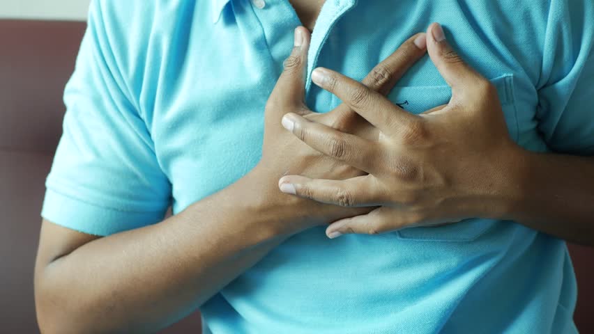 Young man suffering pain in heart and holding chest with hand  | Shutterstock HD Video #1102080359