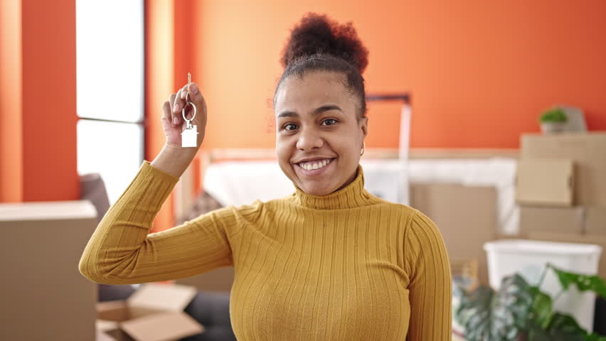 Young african american woman smiling confident showing key at new home