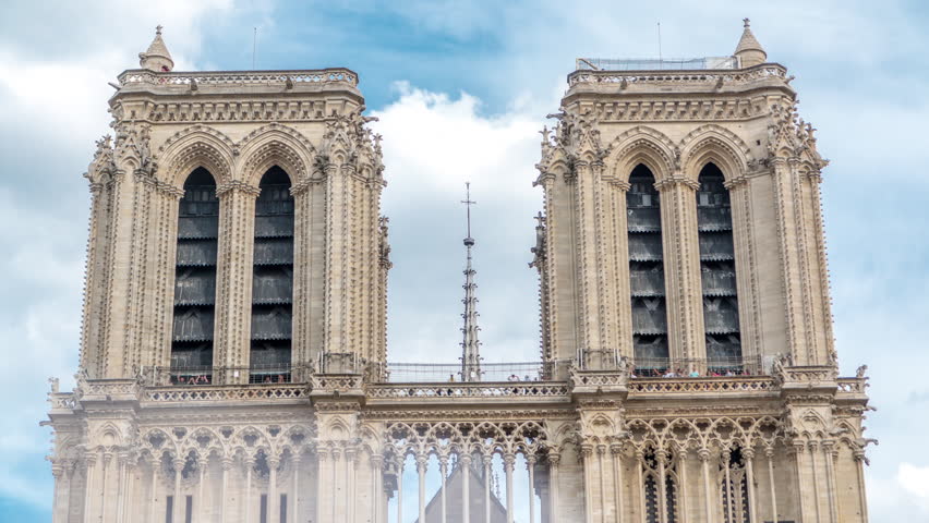Top of Notre-Dame de Paris timelapse with people on observation deck viewpoint. It is a medieval Catholic cathedral on the Cite Island in Paris, France. Cloudy sky at summer day