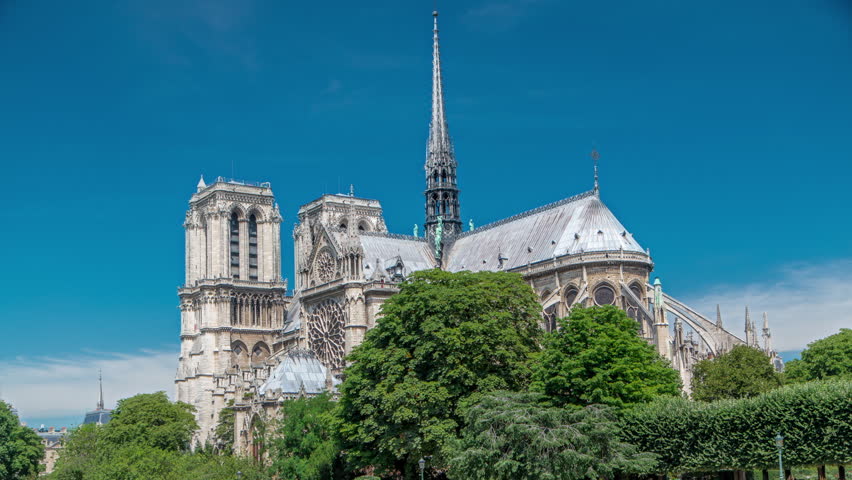 Notre Dame de Paris back side timelapse. One of the most famous symbols of Paris. View from Bridge of the Archbishopric with green trees at sunny summer day