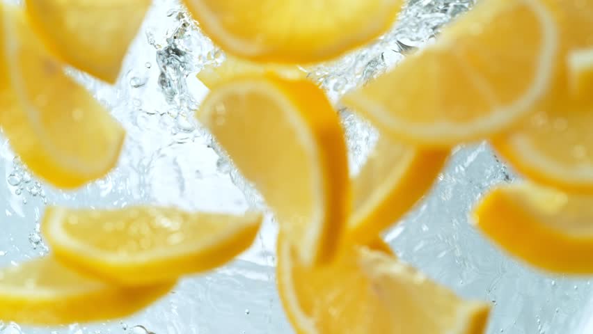 Super Slow Motion Shot of Fresh Lemon Slices Falling into Water Whirl on Light Background at 1000fps | Shutterstock HD Video #1102087785