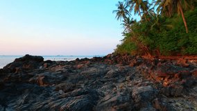 Walking on the rocky beach in Koh Samui during sunset can be a beautiful and peaceful experience. Just make sure to wear comfortable shoes and watch your step on the rocks. Thailand. 4K UHD

