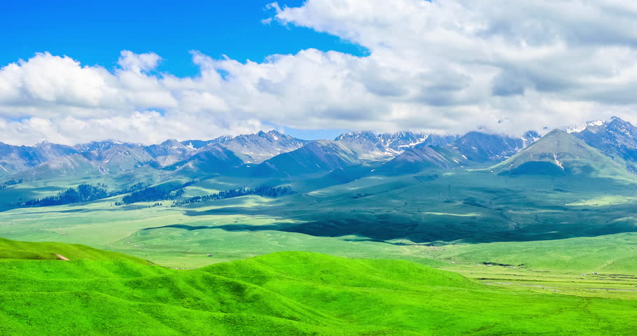 Green grasslands with mountain natural scenery in Xinjiang, China.