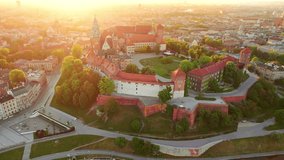 Royal Wawel castle and Vistula river at sunrise in Krakow, Poland. Aerial 4K drone video at sunrise in summer. Old city with St. Mary church, Historic royal Wawel castle in Cracow, Poland. 