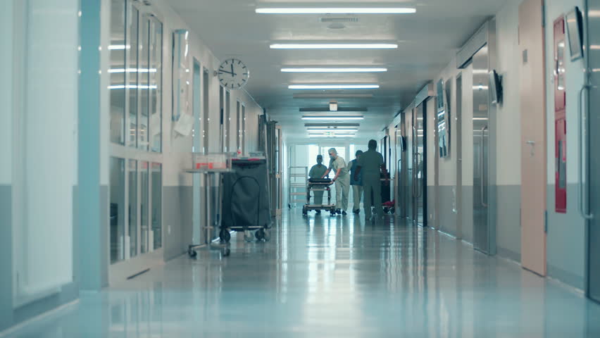 Surgeons are rolling a bed along the hospital hallway