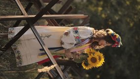 A beautiful Ukrainian girl in a Ukrainian national vyshyvanka dress with a bouquet of sunflowers against the background of anti-tank hedgehogs. war in Ukraine. War of Russia against Ukraine. - Powered by Shutterstock - Get 15% off with code: PIKWIZARD15