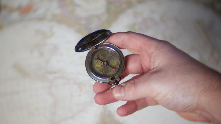 A man uses an antique cbrass compass | Shutterstock HD Video #1102104681