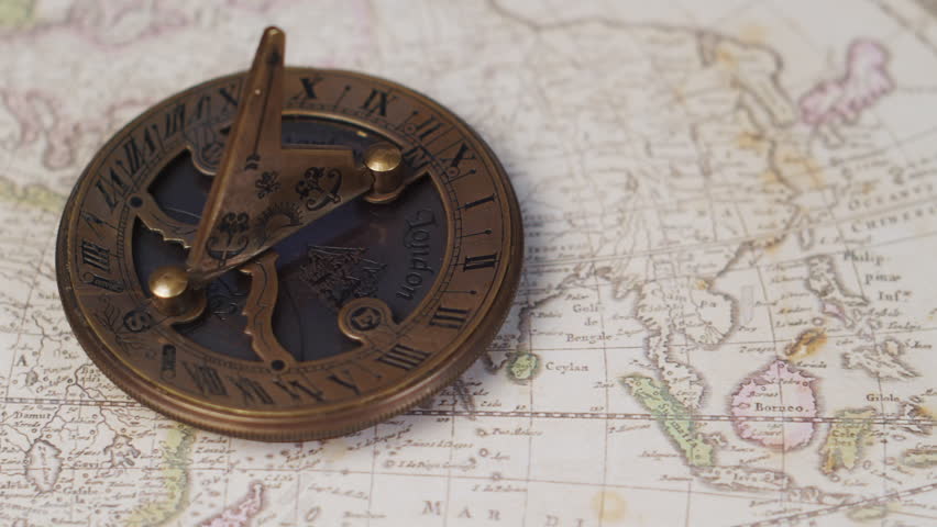 An atique brass sundial navigational instrument on a vintage world map | Shutterstock HD Video #1102104691