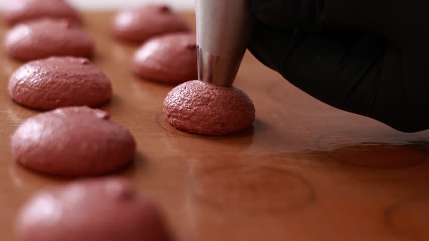 professional chef making base for preparation macaron dessert. Close-up of extruding brawn creme from piping bag on tray For baking base of macaroon dessert. Concept Of Baking, Cooking. close up. Royalty-Free Stock Footage #1102105819