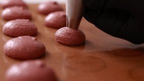 professional chef making base for preparation macaron dessert. Close-up of extruding brawn creme from piping bag on tray For baking base of macaroon dessert. Concept Of Baking, Cooking. close up. - Powered by Shutterstock - Get 15% off with code: PIKWIZARD15