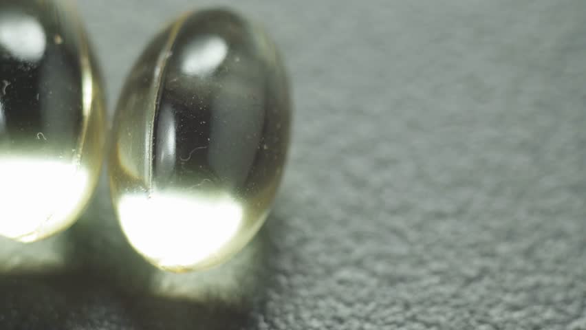 Yellow oil soft gel capsules. Cosmetic pill capsule of vitamin E, A, almond oil, Omega 3, fish.
