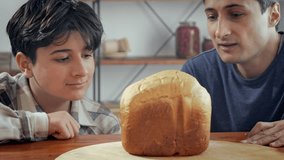 Father and son inhale the aroma of homemade bread and smile. Home cooking. Family values and pastime - Powered by Shutterstock - Get 15% off with code: PIKWIZARD15