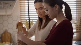 Caucasian mother teaching daughter how cook the soup. Shot with RED helium camera in 8K.  