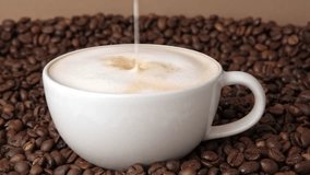 Drop of milk falling in a white cup with black coffee. Side View. Slow Motion. Coffee droplet. Roasted coffee beans background. Freshly brewed latte cappuccino. Close up. Coffee product advertising. - Powered by Shutterstock - Get 15% off with code: PIKWIZARD15