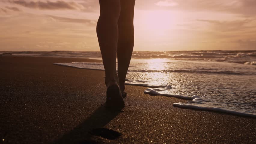 Beautiful Woman Walking on Marine Beach and Wet Legs Shape Moving Closeup. One Adult Girl at Bright Scenic Sea Going Swim or Splash. Modern Romance of Ocean Bathing and Amazing Summer Sky at Sundown Royalty-Free Stock Footage #1102127511