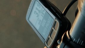 Female finger pressing button on cycle computer ending ride. Vertical video. Professional cyclist recording cycling training using bike computer, close up of device screen. Cycling and triathlon
