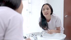 Happy Asian woman brushing her teeth in the bathroom in the morning. - Powered by Shutterstock - Get 15% off with code: PIKWIZARD15