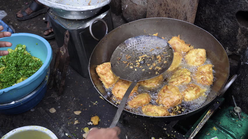 Frying vada in a big oil pan, Mumbai city, India
