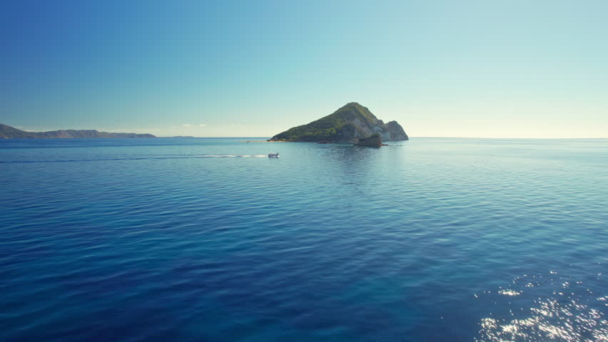 Aerial view of a Marathonisi Island near Zakynthos island in Ionian sea, Greece. Marathon island at sunrise on Zante island. Tourist boat, blue sea, sunny day - perfect Greek holidays
