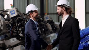 4k video Slow motion of 2 caucasian engineers or businessman handshake in factory workshop, Successful deal after negotiations. handshake of business people wearing hard hats in plant manufacture.