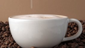 Drop of milk falling in a white cup with black coffee. Side View. Slow Motion. Coffee droplet. Roasted coffee beans background. Freshly brewed latte cappuccino. Close up. Coffee product advertising. - Powered by Shutterstock - Get 15% off with code: PIKWIZARD15