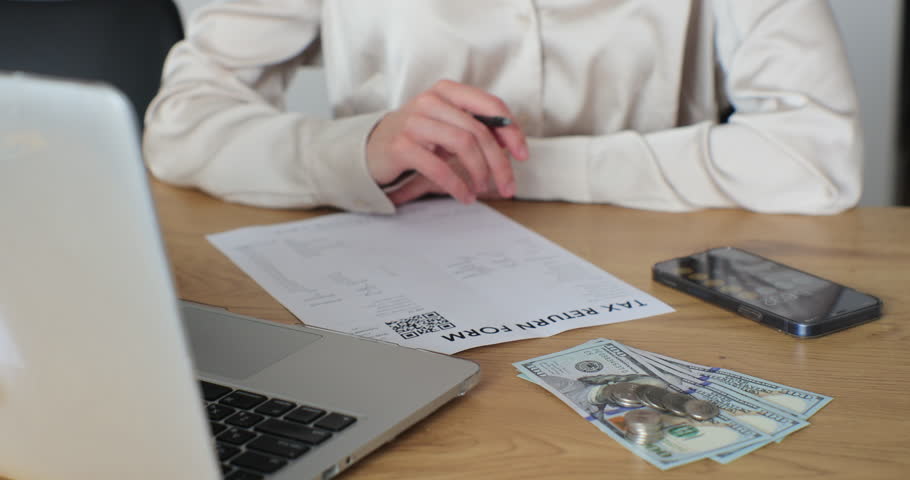 Close up woman filling tax return form. Female calculating expenses and writing on tax document. | Shutterstock HD Video #1102145039