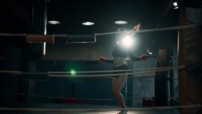 Professional young sportswoman boxer in sportswear with ponytail skipping rope on boxing ring in gym. She training alone. Girl jumping rope. Sport, workout, train, fighter training, jump rope concept. - Powered by Shutterstock - Get 15% off with code: PIKWIZARD15