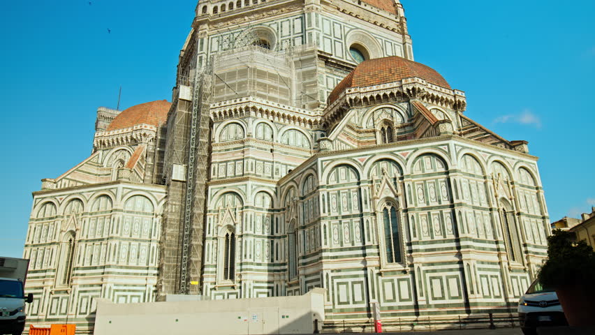 Close-up of the stunning Cathedral of Santa Maria del Fiore. Amazing Landmark cathedral with red-tiled dome, colored marble facade and elegant Giotto tower in Florence, Italy.