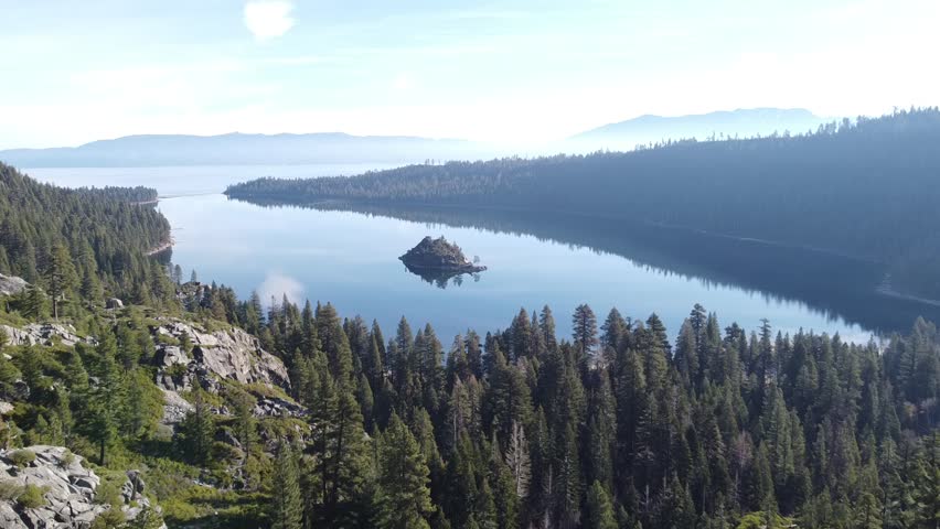 emerald bay lake tahoe blue lake in bay with forest green trees pretty sky clouds sunny day drone