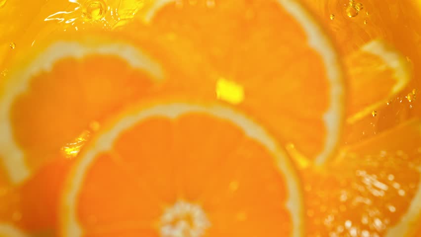 Super Slow Motion Shot of Fresh Orange Slices Falling into Lemonade Whirl at 1000 fps. Royalty-Free Stock Footage #1102151115