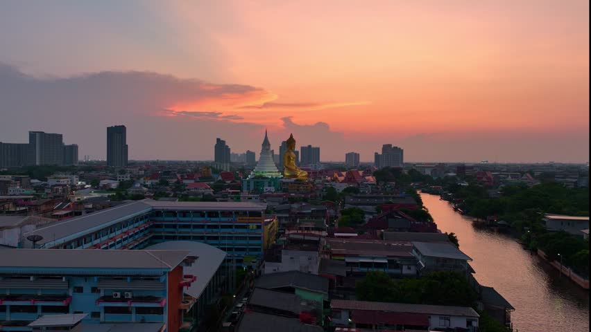 
aerial view golden big Buddha Wat Paknam Phasi Charoen in sunset. 
beautiful sunset reflection on a canal in front big buddha. 
scenery sky in twilight background.the one famous landmarks in Thailand