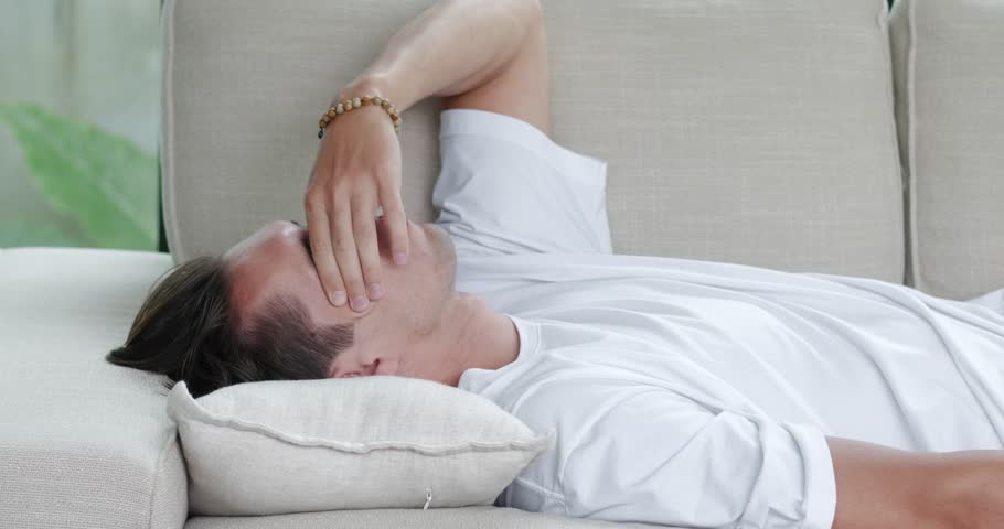 Tired overloaded young man came home after work flopped down on sofa feels like squeezed lemon. Concept of after party, tired overworked person hard day, lack of energy. Hard day concept | Shutterstock HD Video #1102155727